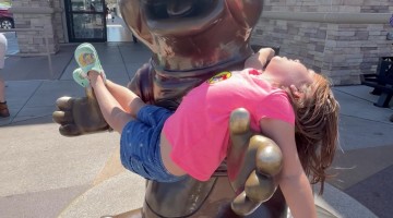 Beaver Mascot Statue Cradles Young Fan