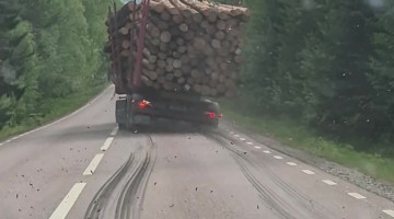Timber Truck Lets Logs Spill Onto Road