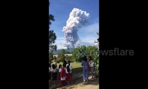 Schoolchildren watch as volcano erupts on quake-hit Indonesia island