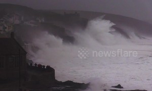 Huge swells and crashing waves in Cornwall as villagers look on