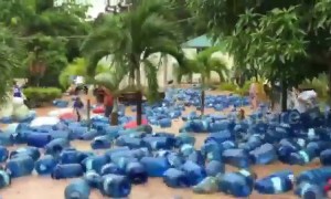 Hundreds of water dispensers float down flooded street after heavy downpour