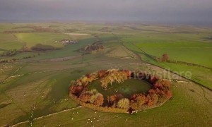 Dawn breaks over ring of autumnal trees in the Peak District in breathtaking drone footage