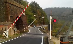 Onlookers watch in awe while old-fashioned steam train crosses bridge