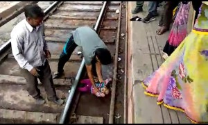 Moment miracle baby emerges unscathed after falling onto tracks and under moving train