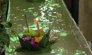 Worshippers send candle-lit baskets down a flume for Loy Krathong festival in Thailand
