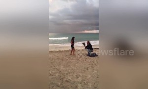 Boyfriend makes surprise beachside proposal under a rainbow