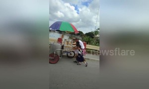 Tender moment schoolchildren help struggling elderly ice cream seller push cart up hill