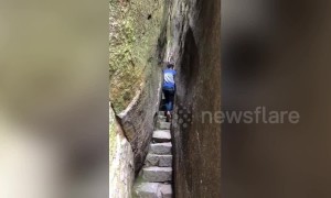Man walks through incredible narrow passage through Chinese mountains