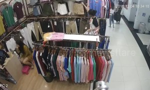Thief steals clothes while shop assistant too busy doing her makeup to notice