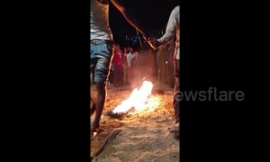 Man pours kerosene on line of fire before walking barefoot over it