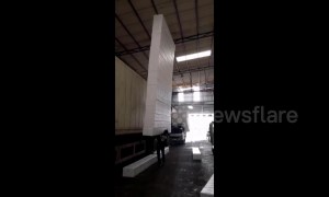 Worker lifts up and balances tower of 18 foam blocks