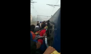 Indian students forced to cling to outside of train to sit police exam