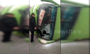 Car hits bus, flipping it over and trapping passengers inside