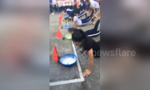 Girls in Vietnam engage in weird flour-eating wheelbarrow race