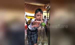 Dizzy kids try to flick lime from bottle top in amusing party game