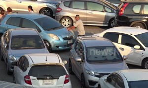 This car park is so packed that drivers have to push vehicles when they want to leave