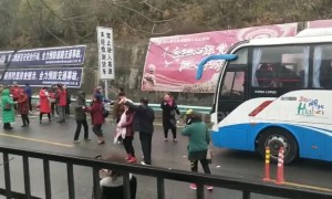 Stranded Chinese tourists get out of their bus and dance on icy motorway