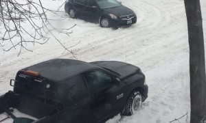 Stuck Car Struggles on Snowy Street