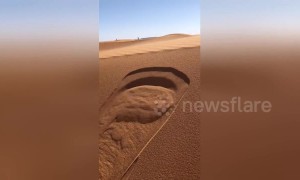 Slight ripple on sand dunes in Sahara creates miniature avalanche