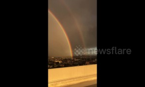 Spectacular double rainbow arcs over Los Angeles cityscape