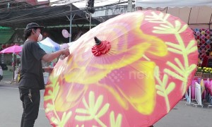 Graffiti artists spray paint contemporary designs on ancient Thai umbrellas