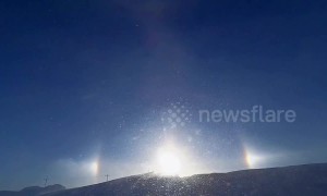 Sundog over snowy hilltop in Minnesota casts brilliant glare during blizzard