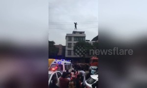 Alleged drunk man tight-rope walks on high voltage power lines