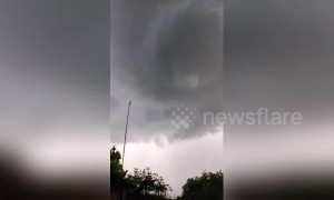 People watch a destructive whirlwind form above their heads in Indonesia