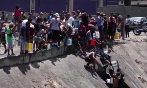 Scores of Venezuelans collect water from river as power outage crisis continues