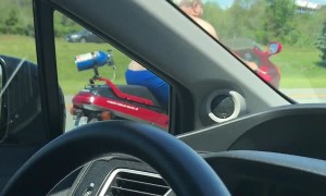 Shirtless Man Moseys Down Highway on Motorcycle