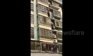 Heroic men climb four floors on building exterior to rescue child hanging from window