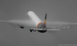 Condensation clouds engulf plane's wings as it takes off from Manchester Airport