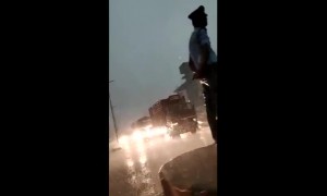 Neither wind nor rain stops this Indian traffic cop from doing his job