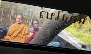 Terrified Buddhist monk looks on nervously as wild ELEPHANT raids pickup truck