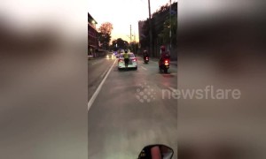 Man hitches a ride on the back of a taxi to avoid paying in The Philippines