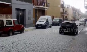 Unseasonal hailstorm pummels cars parked on a street in Barcelona