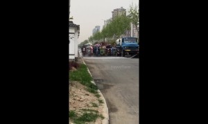Bizarre moment moped riders patiently drive behind van spraying water in China