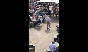 Having the time of his life! Elderly man dances in front of crowd in beer garden