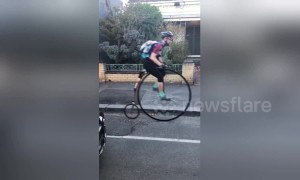 Melbourne man in full cycle gear surprises commuters on Penny-farthing