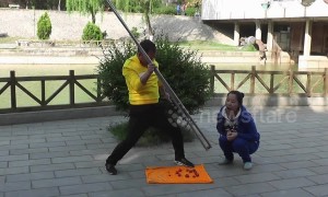 Chinese man uses giant chopsticks to feed fruit to woman