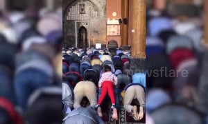 Watch playful girl riding devotee's back during prayer inside mosque in northern India