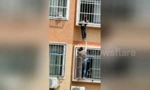 Heroic Chinese man holds up boy hanging from seventh-floor window until help arrives
