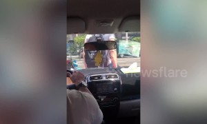 Angry tourist late for taxi booking sits on bonnet to stop car from leaving without him