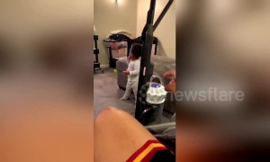 Dad startles adorable baby into walking with vacuum cleaner