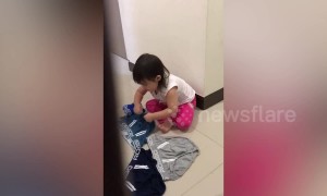 Adorable little girl secretly helps with the laundry