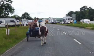 Travellers ride their horse-drawn carts ahead of the Appleby Horse Fair