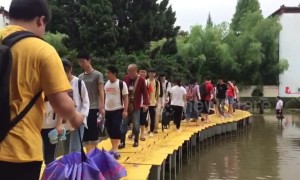 Teachers use tables to build bridge so students can walk across flooded courtyard in China