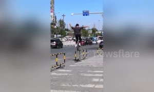 Daredevil unicyclist balances on roadside guardrails in China