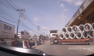Concrete pipe falls off truck nearly crushing drivers on busy road in Thailand