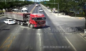 Truck driver narrowly avoids flattening car after changing directions quickly in China